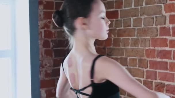 Balett tánc otthon - egy kis torna lány táncol fekete öltönyben edzés közben — Stock videók