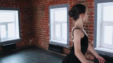 Bale içeride dans ediyor. Siyah kostümlü küçük bir kız dans ediyor.