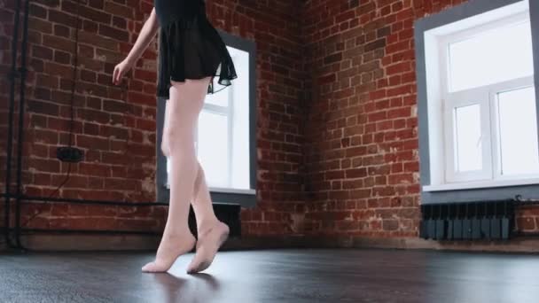 Балет в помещении - маленькая девочка, исполняющая танец в черном костюме в студии — стоковое видео