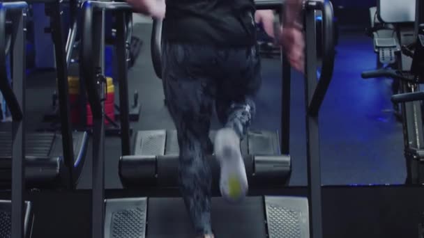 Sportif bir adam spor salonundaki koşu bandında aynanın önünde koşar. — Stok video