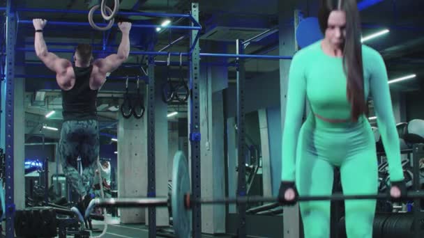 Mann und Frau beim Training im Fitnessstudio - ihre Armmuskeln pumpen — Stockvideo