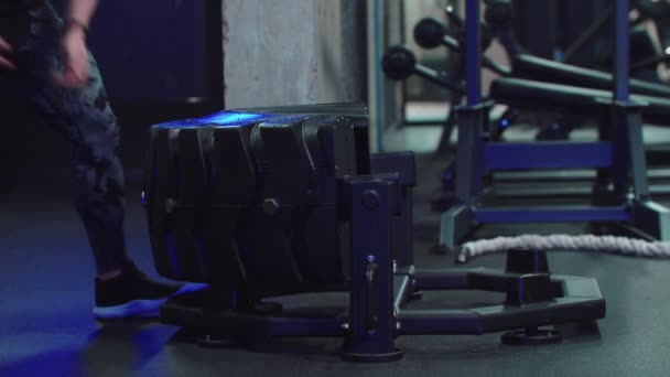 Ein männlicher Bodybuilder dreht Gewicht um und springt darüber - Training im Fitnessstudio — Stockvideo