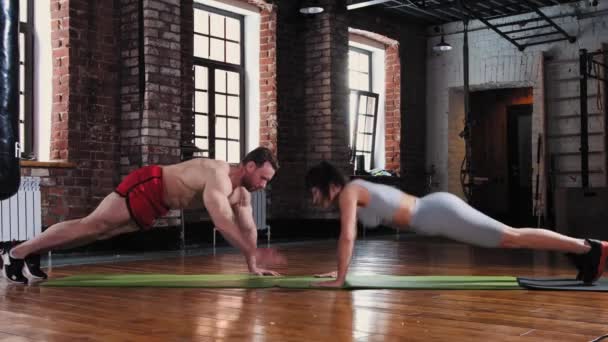 Paar in de sportschool - samen push-ups doen op yogamatten — Stockvideo