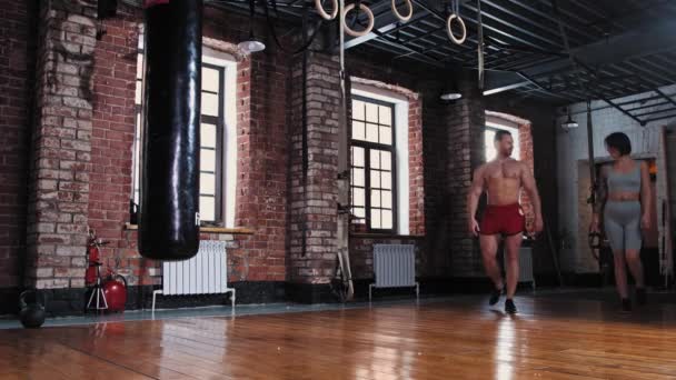 Hombre y mujer entrando en el gimnasio y comienza a calentar su cintura — Vídeos de Stock