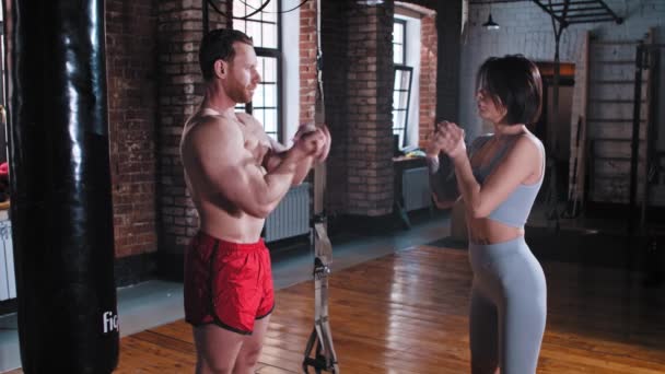 Egy pár edzés a tornateremben - férfi és nő melegíti a kezüket és a csuklójukat — Stock videók