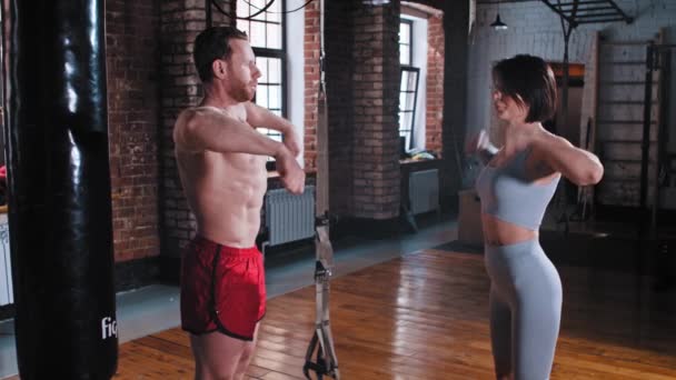 A couple training in the gym - man and woman warming up their hands — Stock Video