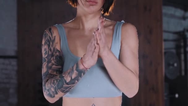 Attraktive, fitte Frau, die ihre Hände mit Kreide bedeckt — Stockvideo
