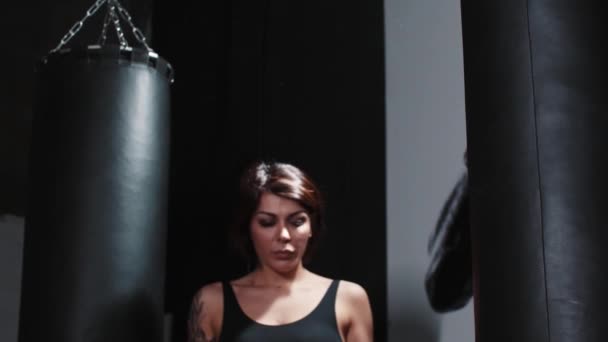 Татуированная женщина связывает руки перед тренировкой в спортзале — стоковое видео