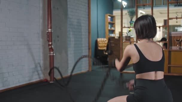 Une femme dans la salle de gym faisant un exercice de corde Crossfit — Video