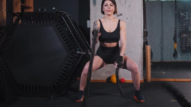 Сильная женщина, делающая упражнения на веревке — стоковое видео