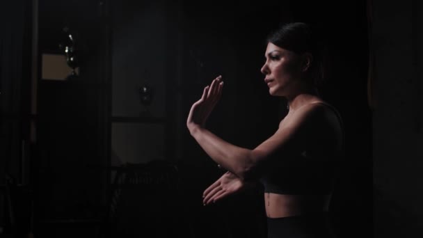 Сильная женщина с татуировками, показывающая движения боевых рук карате — стоковое видео