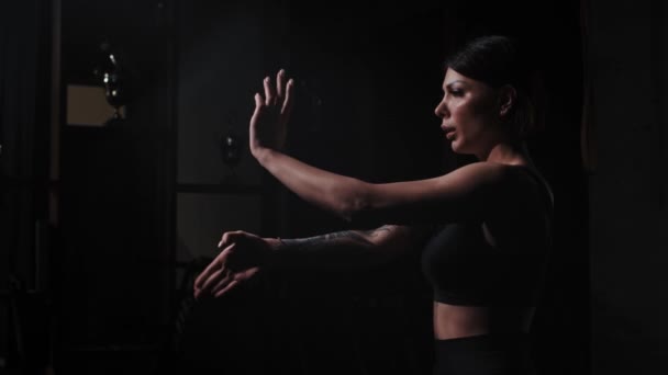 Une femme tatouée forte montrant des mains de karaté bouge et respire lourdement — Video
