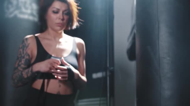 Tetovaná žena svazuje ruce před box školení v šatně — Stock video