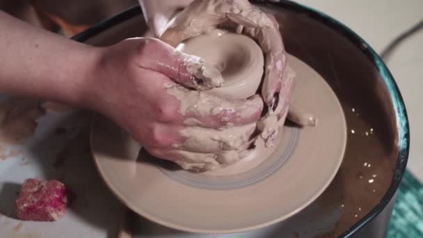 Vrouwen handen vormen klei in een langere vorm op een pottenbakkerswiel — Stockvideo