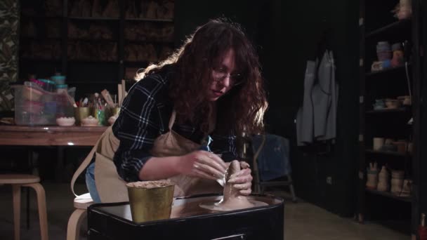 La fabricación de la cerámica en el estudio de arte - las manos femeninas forman la arcilla en una forma más larga en una rueda de alfarero — Vídeo de stock