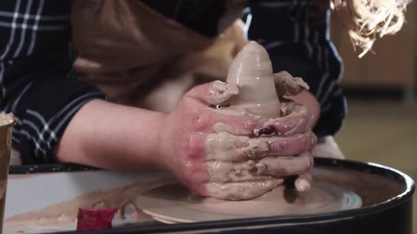 A woman artist forms clay in a longer shape on a potters wheel — Stock Video