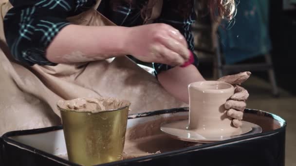 Elaboración de cerámica - las manos de la mujer forma arcilla en la forma de una olla simple pequeña — Vídeos de Stock