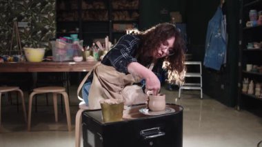 Stüdyoda çömlekçilik - kadın basit bir tencere oluşturur