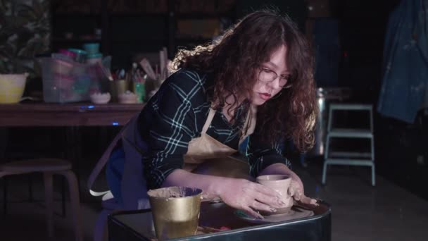 Виготовлення кераміки в художній студії - жінка формує простий горщик з мокрої глини — стокове відео