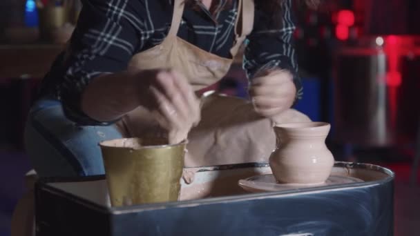 Rzemiosło ceramiczne - kobieta z kręconymi włosami robi garnek z mokrej gliny przy użyciu małej gąbki — Wideo stockowe