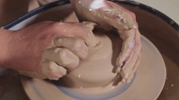 Pottery crafting - making a recess in the wet clay with a finger on the potters wheel — Stock Video