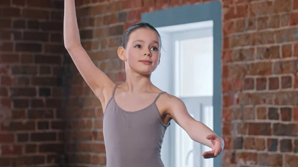 Küçük güzel bir balerin kız stüdyoda eğitim hareketleri yapıyor. — Stok fotoğraf