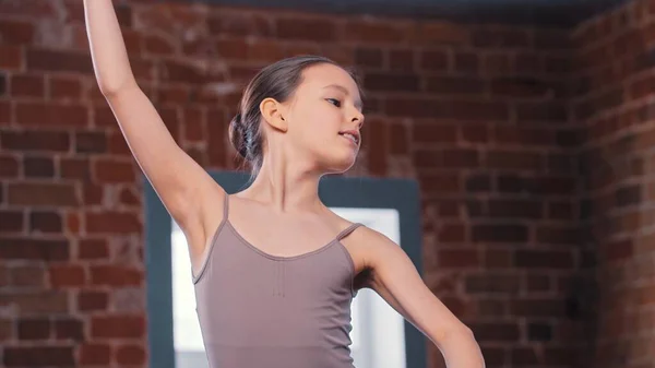 Um pouco de bailarina menina movimentos de treinamento no estúdio — Fotografia de Stock