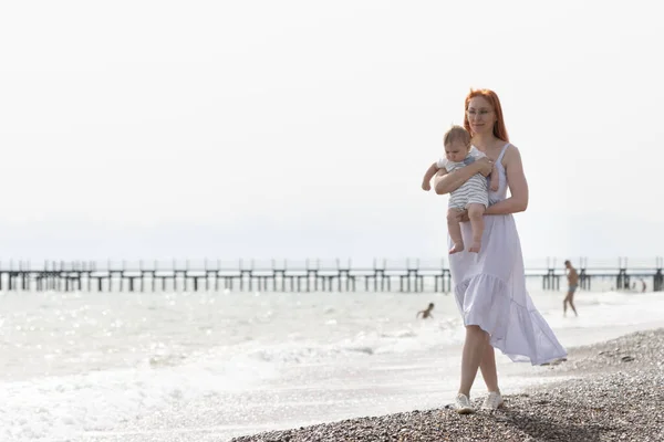 Мати гуляє на пляжі зі своїм маленьким сином — стокове фото