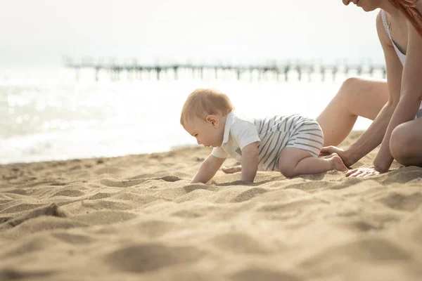 Ein kleiner Junge krabbelt auf einem Sand am Meer — Stockfoto