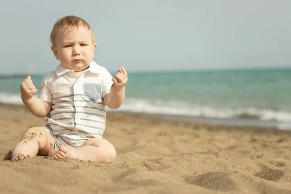 Хлопчик сидить на піску на узбережжі — стокове фото