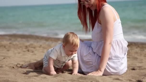 Mãe feliz com seu filhinho tendo um descanso na praia — Vídeo de Stock