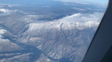 Bir uçağın penceresinden dağlara bak.