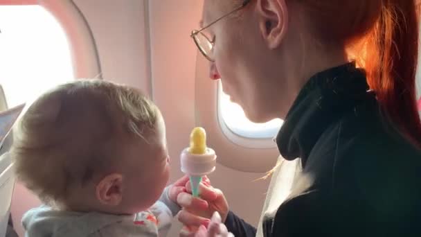 Kobieta i dziecko siedzą wewnątrz samolotu — Wideo stockowe