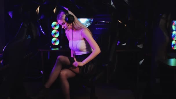 Блондинка сексуальный геймер девушка стример сидя в игорном клубе и надевая рыбные сетки чулки — стоковое видео