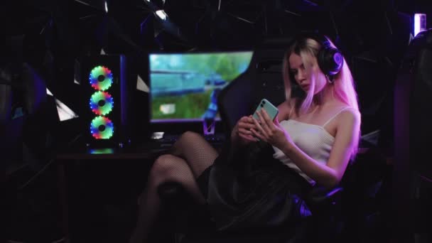 Jovem atraente gamer mulher sentado ao lado do PC tomando uma selfie no clube de jogos — Vídeo de Stock