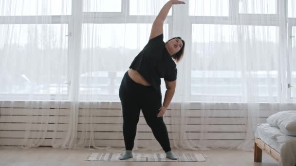 Толстая женщина делает упражнения дома — стоковое видео