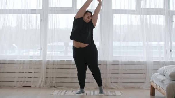Tlustá žena, která doma cvičí. — Stock video