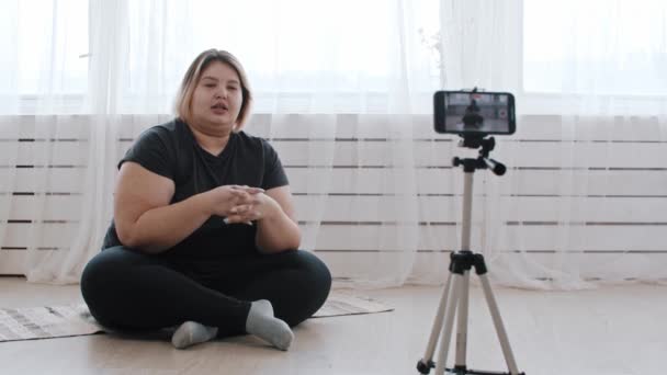 Een zelfverzekerde vrouw met overgewicht feminist in gesprek op een video voor haar volgelingen over positiviteit van het lichaam — Stockvideo