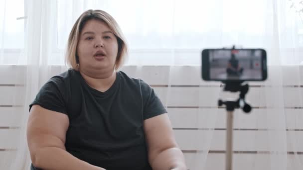 Pewna siebie kobieta z nadwagą feministka kręci film z operatorem dla swoich zwolenników o pozytywności ciała — Wideo stockowe