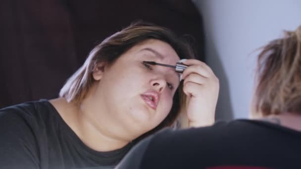 Žena s nadváhou, která si nanáší řasenku na řasy — Stock video
