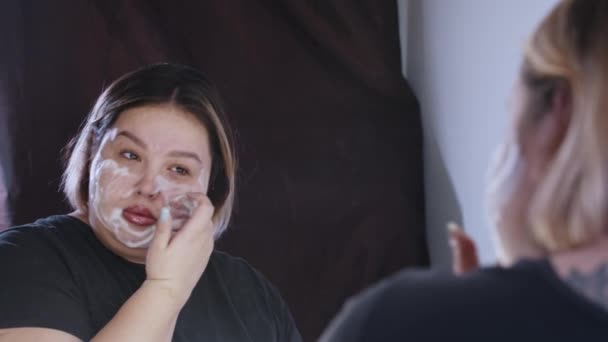 鏡の前で顔を掃除する太りすぎの女性 — ストック動画