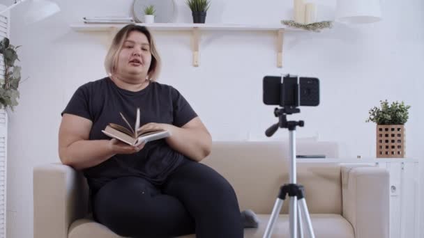 Vücut pozitifliği - koltukta uzanmış kendine güvenen şişman kadın feminist ve takipçileri için vücut pozitifliği hakkında bir video hazırlıyor. — Stok video