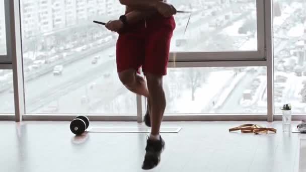 Gespierde man springt over touw op de achtergrond van panoramische ramen — Stockvideo