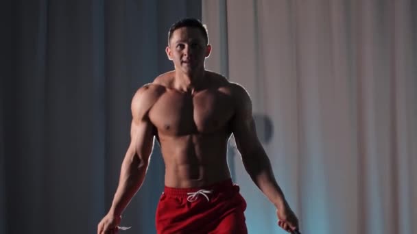Trening sportowy - muskularny mężczyzna bez koszulki skaczący po linie na siłowni — Wideo stockowe