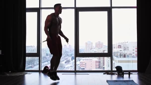Stüdyoda panoramik pencereli spor eğitimi - ipin üzerinden atlayan bir siluet — Stok video