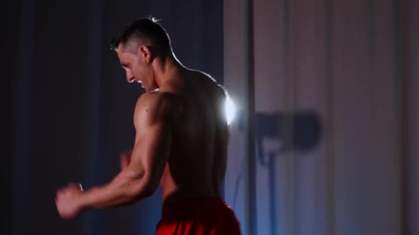 Entrenamiento deportivo - atlético musculoso sonriente posando y mostrando sus músculos — Vídeo de stock