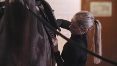 Eyer takan bir kadın tasmalı bir at