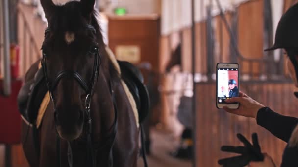 Paardensport - een vrouw die een selfie maakt in de paardenstal — Stockvideo