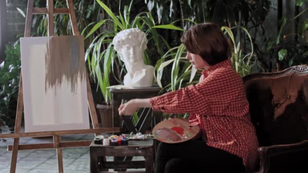 Καλλιτέχνης σε εργαστήριο - νεαρή γυναίκα που αναμιγνύει χρώματα σε παλέτα — Αρχείο Βίντεο