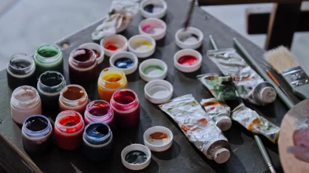 Jovem desenhando uma pintura - misturando cores na paleta — Vídeo de Stock
